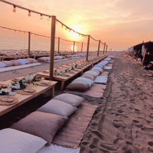 Antalya sahil düğünü organizasyonu için kumsalda yer minderli ve gün batımı manzaralı bohem konsept dekorasyon.